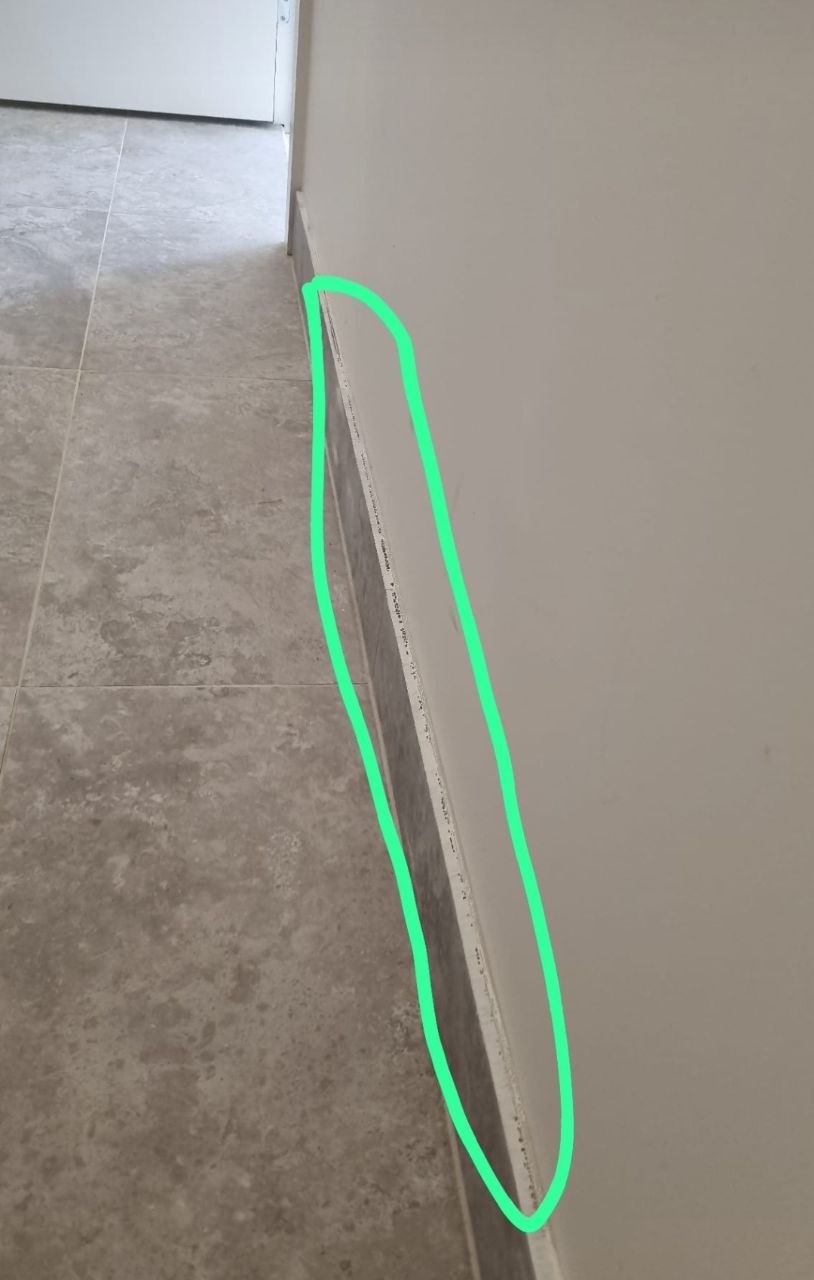 Defect report photo from a Melbourne new build, unfinished skirting caulking circled for the builder before handover
